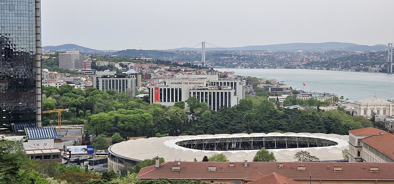Swissôtel The Bosphorus above a wooded slope, with the Bosphorus and a bridge behind it